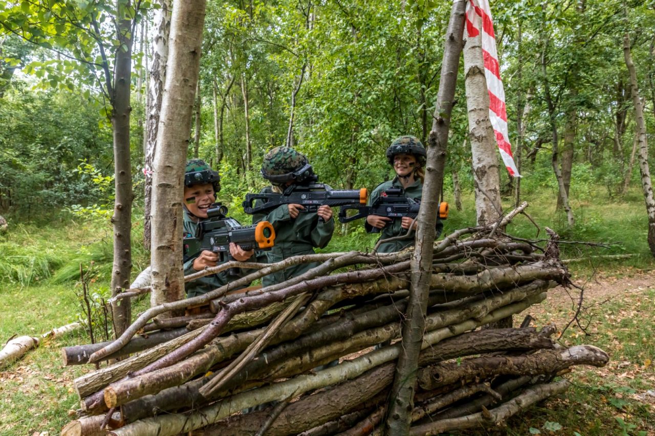 Drie kinderen verdedigen de vlag met lasergamen op het Rutbeek